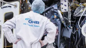 OHB engineer in a cleanroom coat working on spacecraft hardware